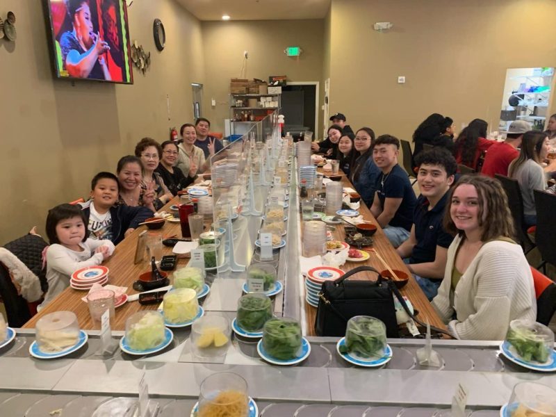 A long table of guests eating hot pot together in the dining room